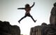 Woman jumping over a cliff without fear