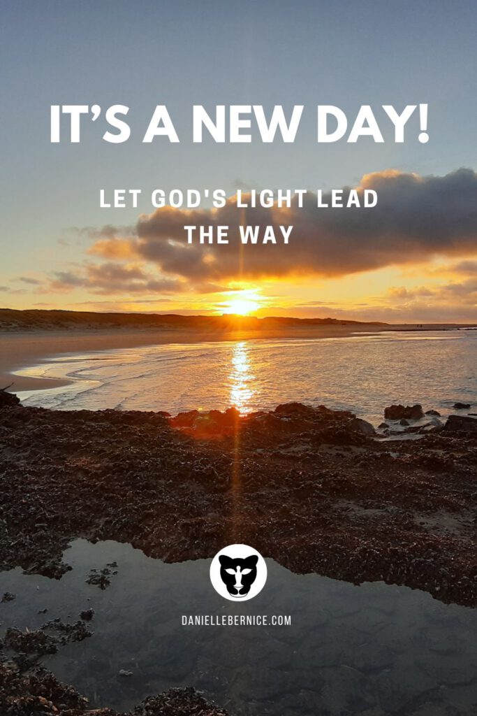 Photograph of the sun rising upon a shore, with clear rays of sunlight beaming across heaven and earth. The text reads: It's a new day! Let God's Light lead the way. DanielleBernice.com